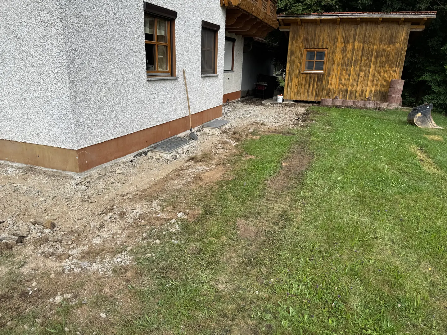 Geöffneter Randstreifen entlang der Hauswand.